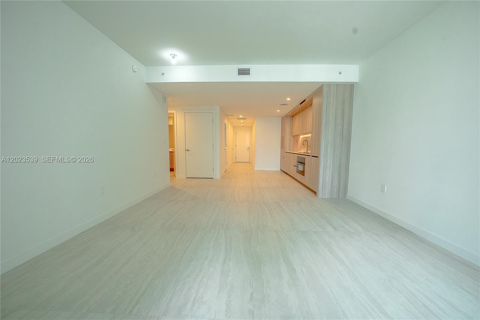 An open-concept room features light-colored tile flooring, white walls, and a modern kitchenette — 77 SE 5th St # 2203, Miami FL 33131, MIAMI, FL