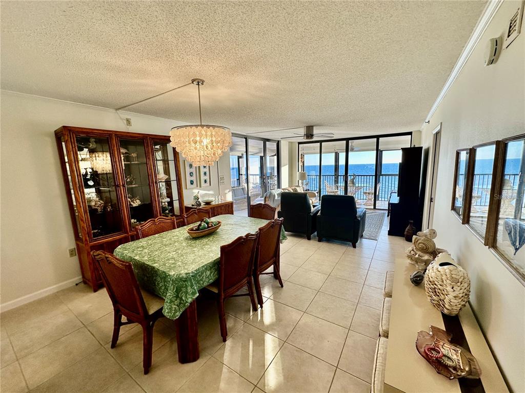 A dining area with a green tablecloth and a view of the ocean through windows — 15462 GULF BOULEVARD UNIT 501, MADEIRA BEACH, FL