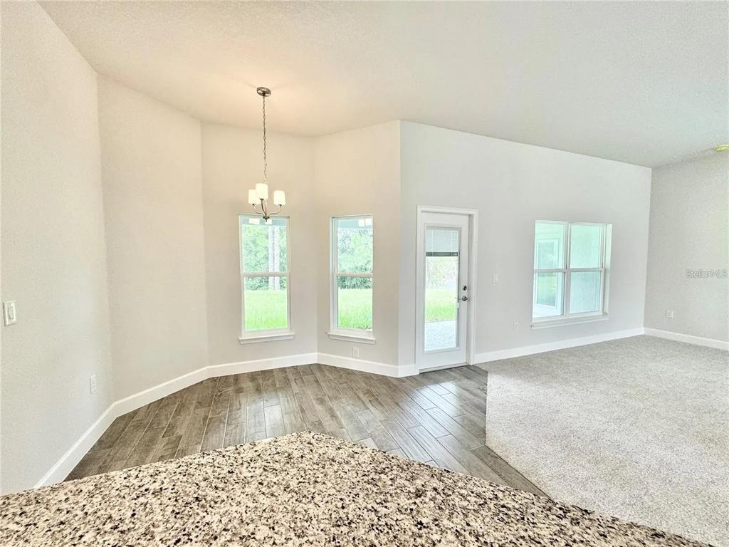 A dining area with a chandelier, tile flooring, and a glass door leading outside — 17745 SW 72ND STREET ROAD, DUNNELLON, FL