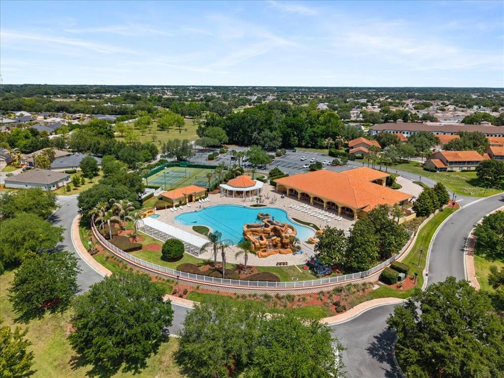 An aerial view of a community clubhouse featuring a swimming pool, tennis courts, and parking — 5336 EDGEWATER WAY UNIT 5336, OXFORD, FL