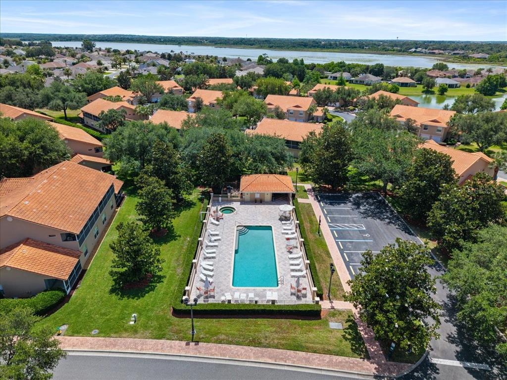 An aerial view shows a community swimming pool and parking lot surrounded by residential homes — 5336 EDGEWATER WAY UNIT 5336, OXFORD, FL