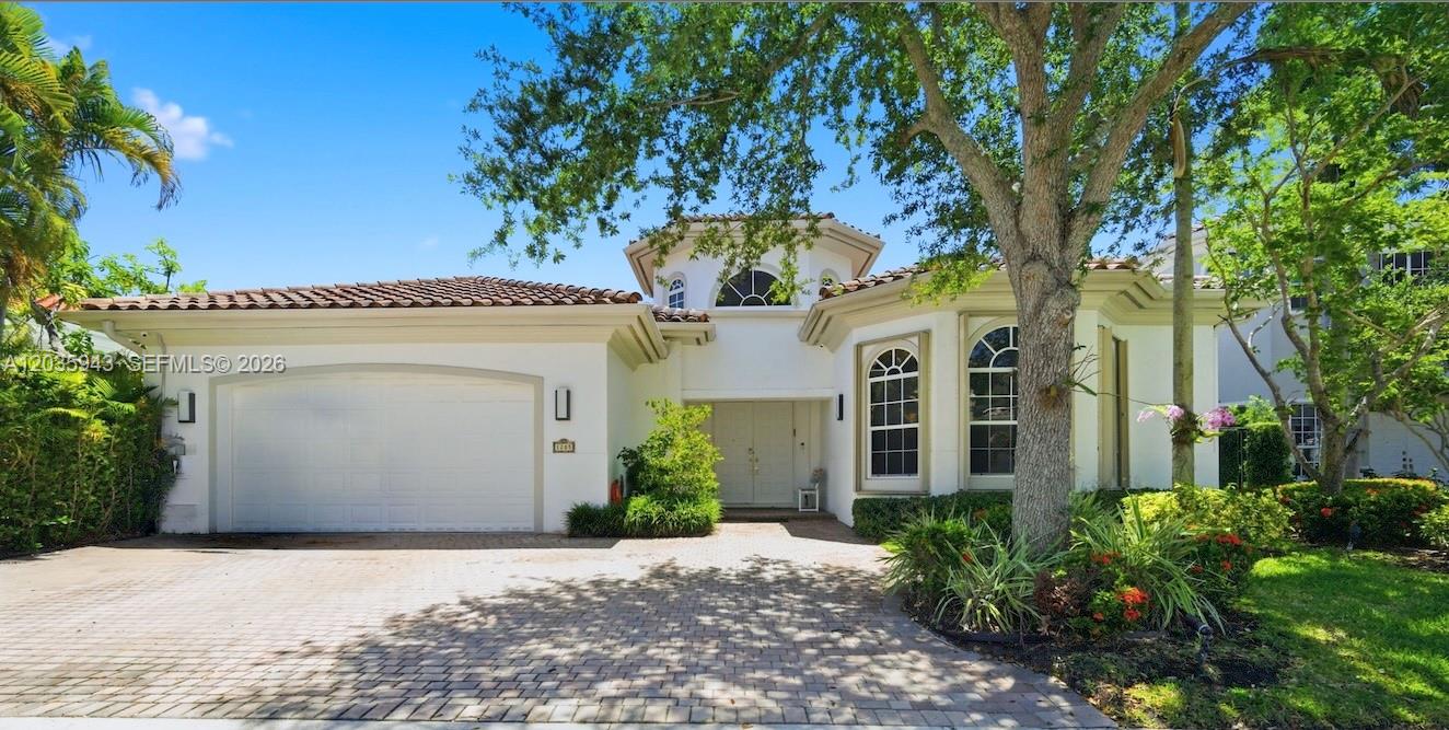 A single-story white house with a tile roof, arched windows, and a paved driveway — 1205 Seagull Ter, Hollywood FL 33019, HOLLYWOOD, FL