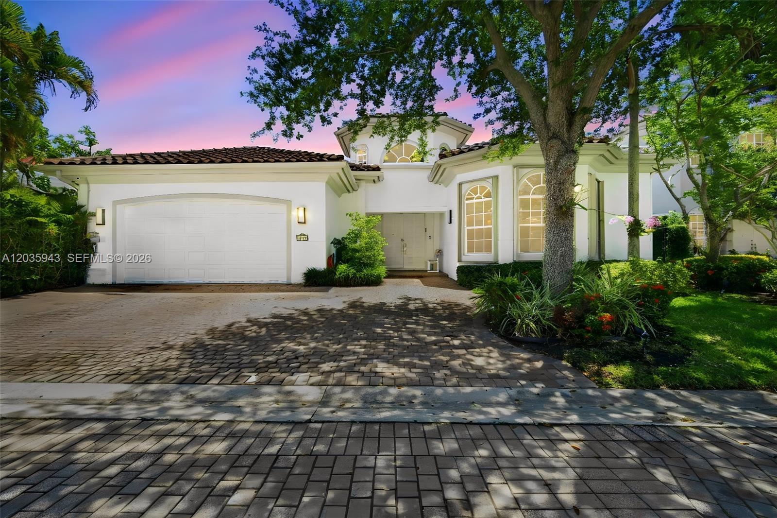 A white single-story house with a tiled roof, arched windows, and a brick paver driveway — 1205 Seagull Ter, Hollywood FL 33019, HOLLYWOOD, FL