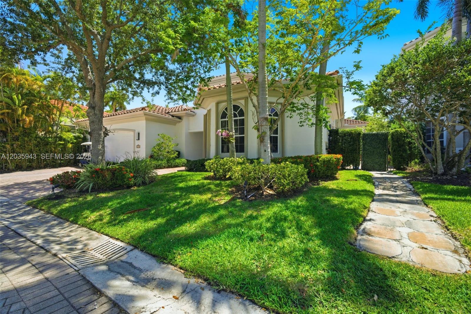 A single-story house with a white exterior, arched windows, and a stone walkway — 1205 Seagull Ter, Hollywood FL 33019, HOLLYWOOD, FL