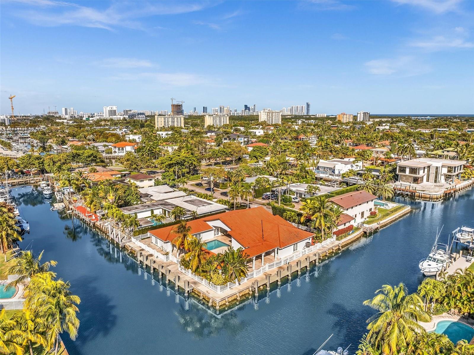 An aerial view shows a waterfront house with a red roof and swimming pool — 12904 Banyan Rd, North Miami FL 33181, NORTH MIAMI, FL