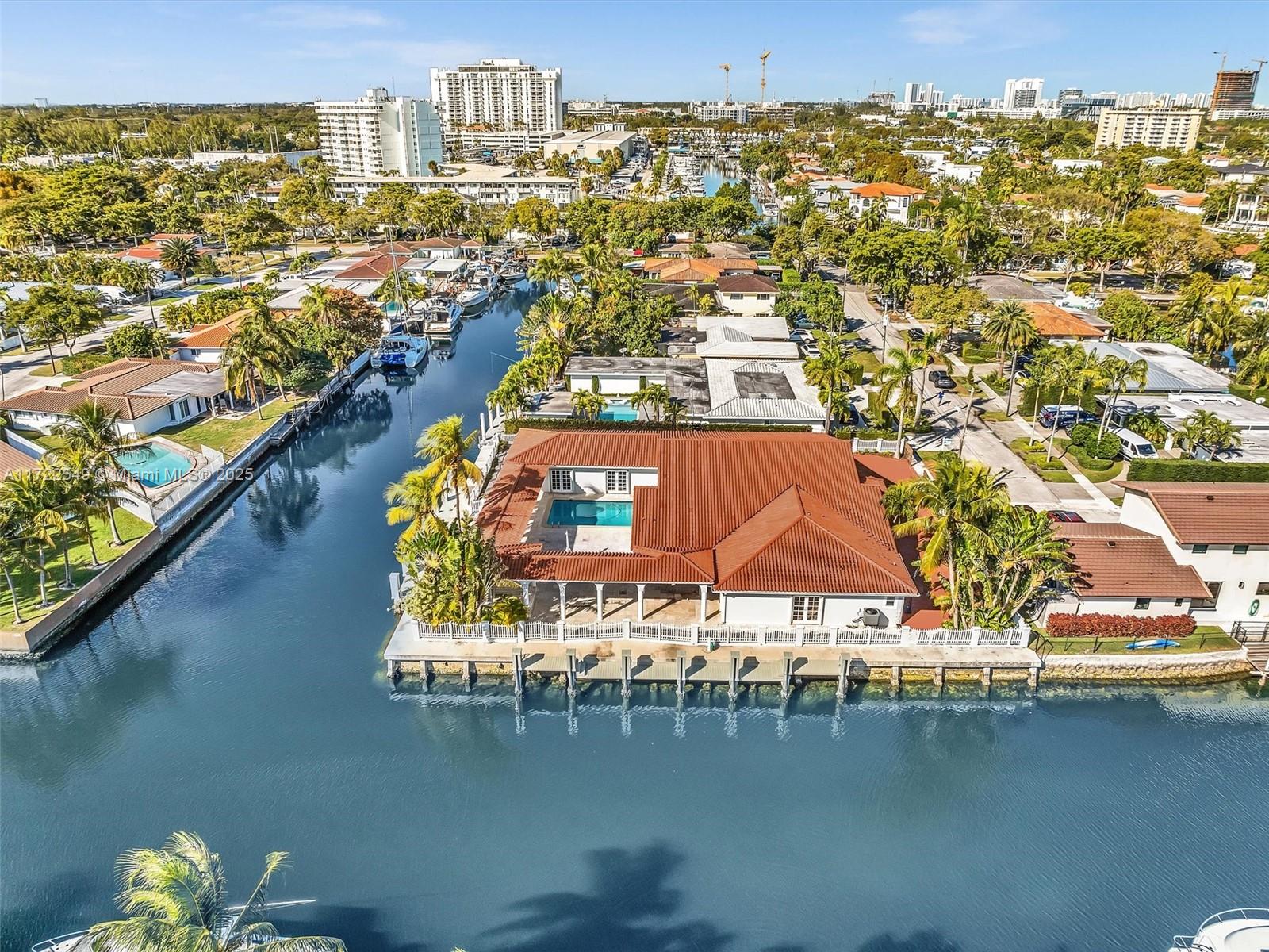 An aerial view shows a waterfront house with a red tile roof and swimming pool — 12904 Banyan Rd, North Miami FL 33181, NORTH MIAMI, FL