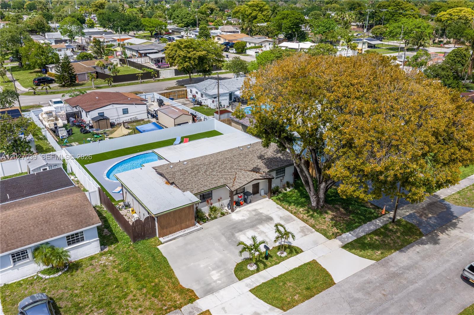 An aerial view shows a single-story house with a swimming pool and a large tree — 7051 Tyler St, Hollywood FL 33024, HOLLYWOOD, FL