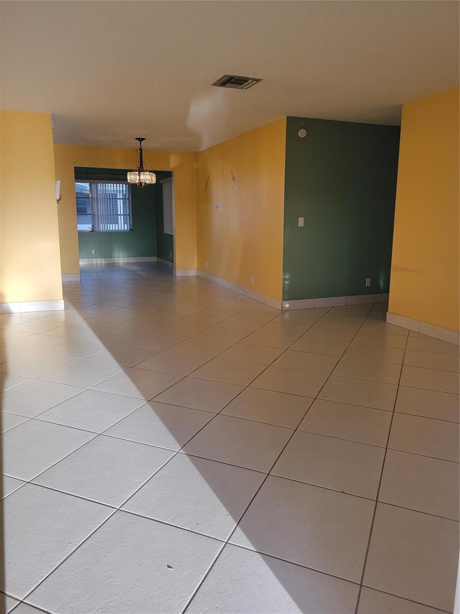 An interior view shows a living area with yellow and green walls and tiled floors — 1170 NW 90th Avenue, Plantation FL 33322, PLANTATION, FL