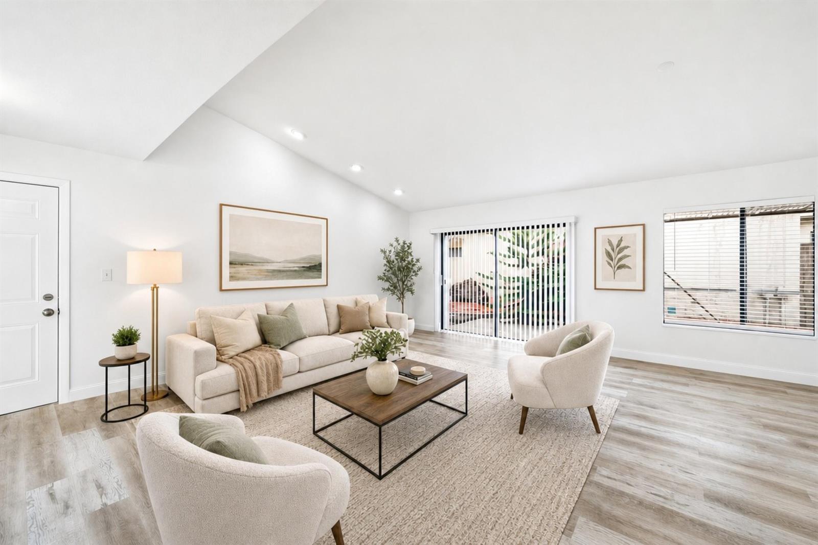A bright living room features a vaulted ceiling, light wood flooring, and neutral furniture — 905 NW 22nd Avenue, Delray Beach FL 33445, DELRAY BEACH, FL