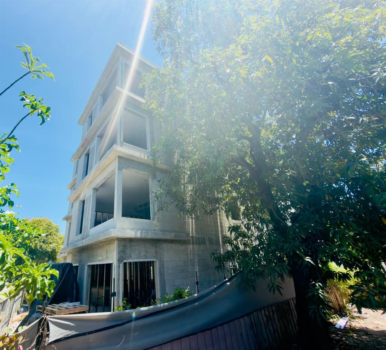 A multi-story concrete building under construction stands next to a large, leafy tree — 259 NW 33rd Street # 4, Miami FL 33127, MIAMI, FL