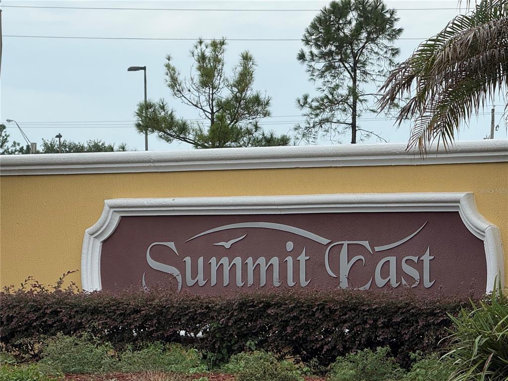 A sign for Summit East stands in front of trees and a hedge — 7158 SUMMIT PLACE, WINTER HAVEN, FL