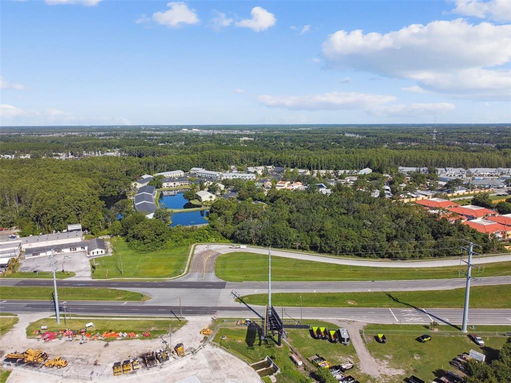 An aerial view shows a road, a construction site, and a residential complex with ponds — 1703 DALE MABRY HIGHWAY, LUTZ, FL
