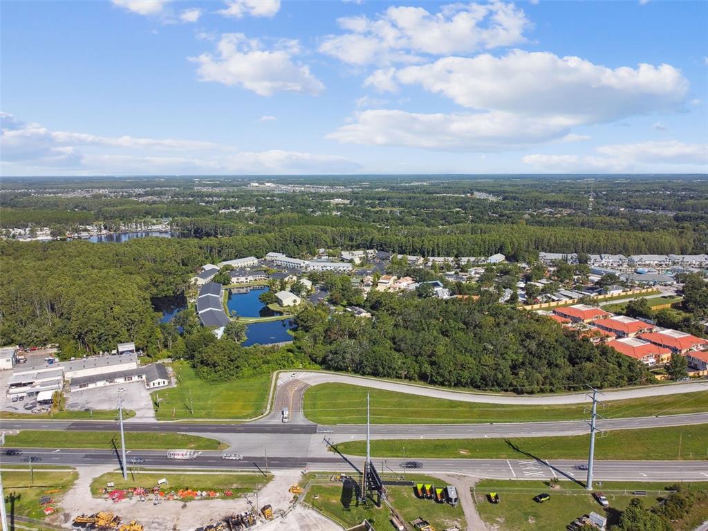 An aerial view shows a multi-building complex with a pond near a highway — 1703 DALE MABRY HIGHWAY, LUTZ, FL