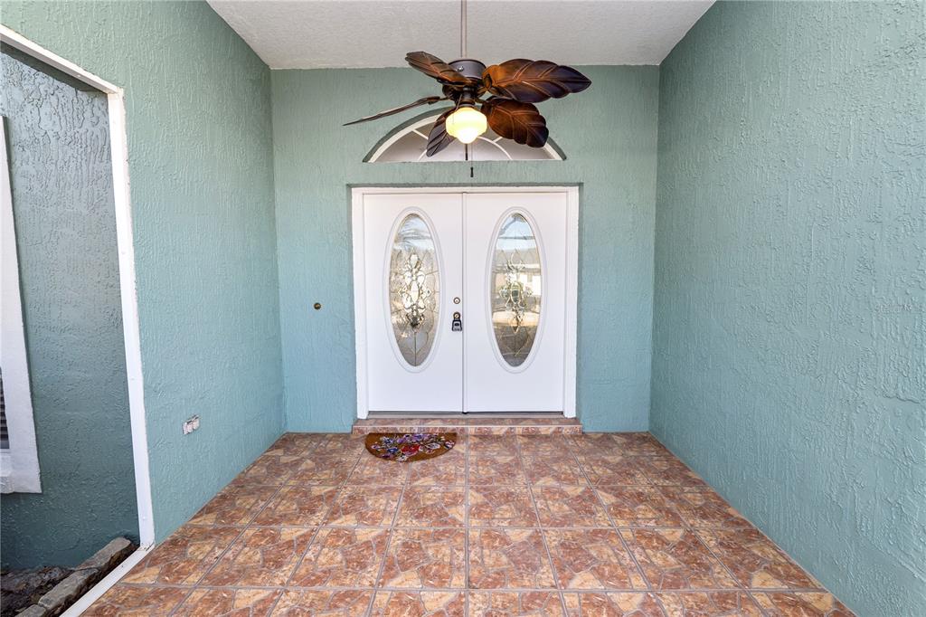 A covered entryway features a tiled floor, double front doors, and a ceiling fan — 2258 COLONY CLUB DRIVE, LAKELAND, FL