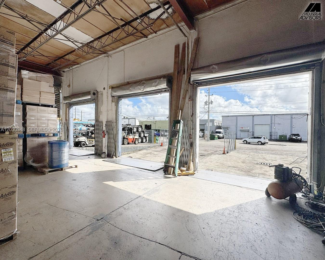 An industrial warehouse interior features open loading bays, concrete floors, and stacked inventory pallets — 7435 W 20th Ave, Hialeah FL 33014, HIALEAH, FL