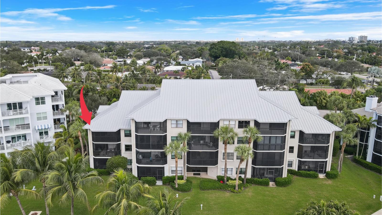 An aerial view of a multi-story apartment building with screened balconies and a metal roof — 235 Bay Colony Drive N, Juno Beach FL 33408, JUNO BEACH, FL