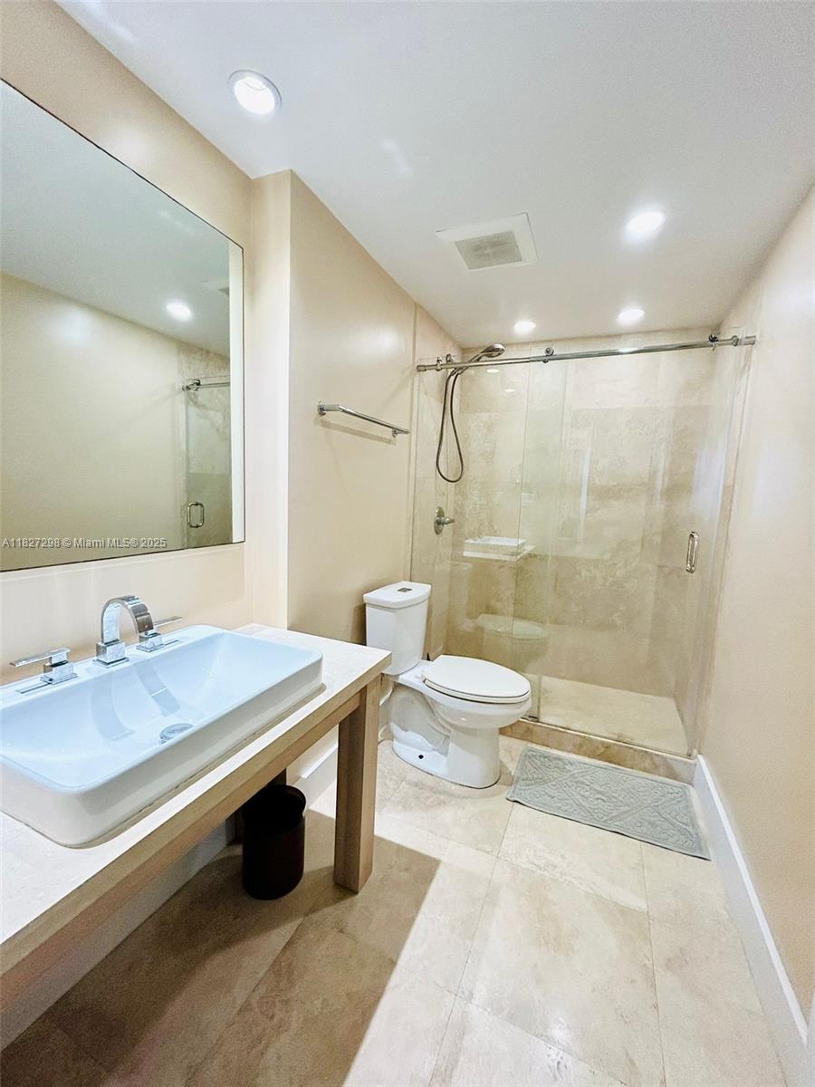 A bathroom features a vessel sink, a glass-enclosed shower, and light-colored tile flooring — 100 Lincoln Rd # 1429, Miami Beach FL 33139, MIAMI BEACH, FL