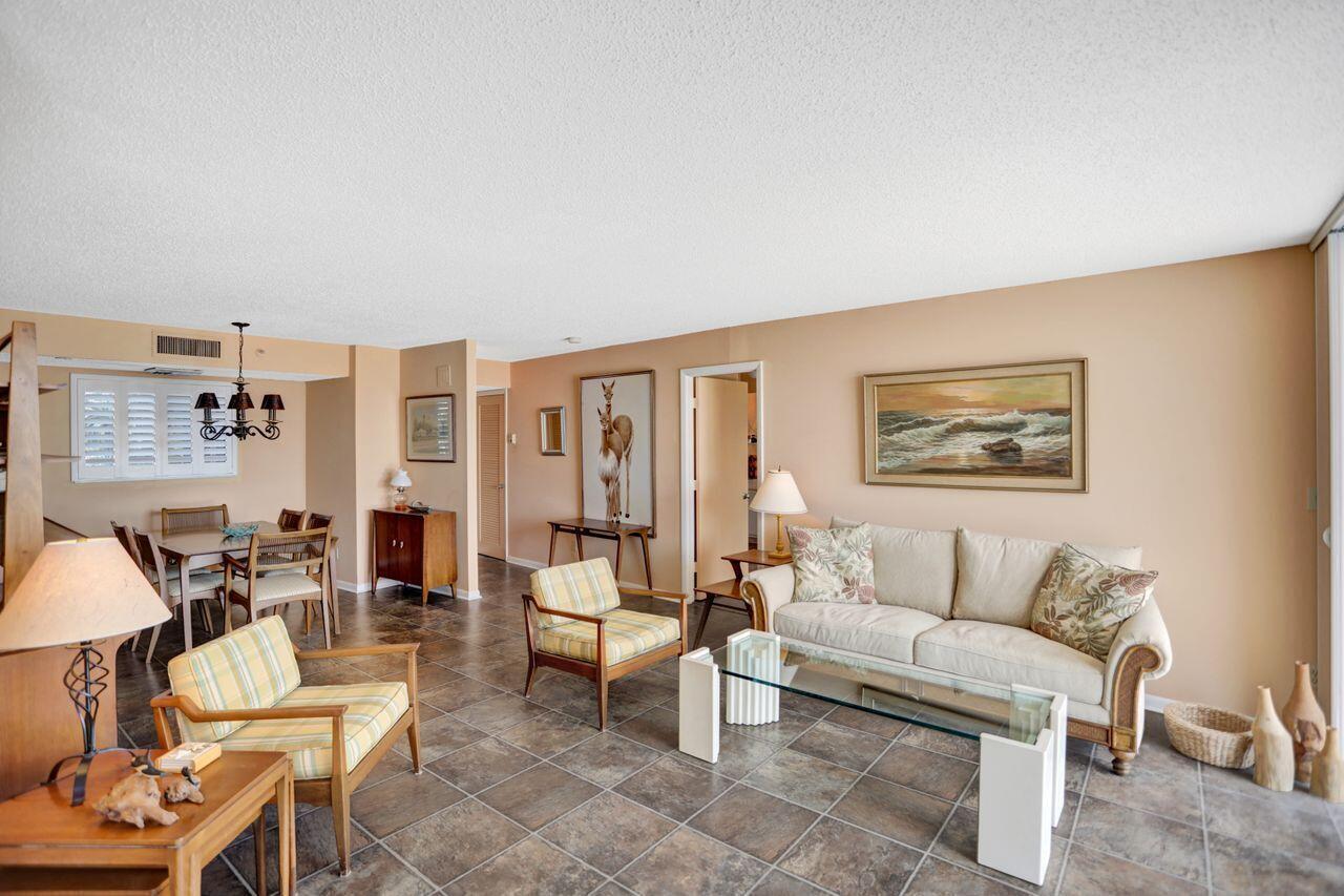 A living and dining area with tile floors, a beige sofa, and two plaid armchairs — 100 Ocean Trail Way # 109, Jupiter FL 33477, JUPITER, FL