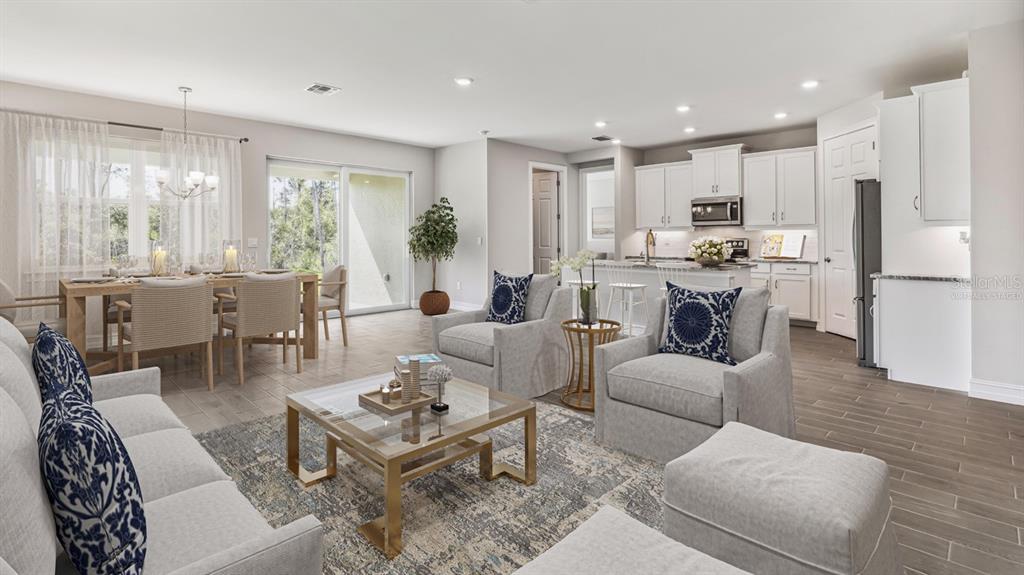 This open-concept living and dining area features tile flooring, white cabinetry, and neutral furniture — 12769 SEAGRASS DRIVE, PUNTA GORDA, FL