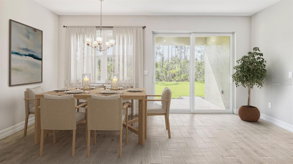 A dining room with a wooden table, six chairs, a chandelier, and sliding glass doors — 12769 SEAGRASS DRIVE, PUNTA GORDA, FL