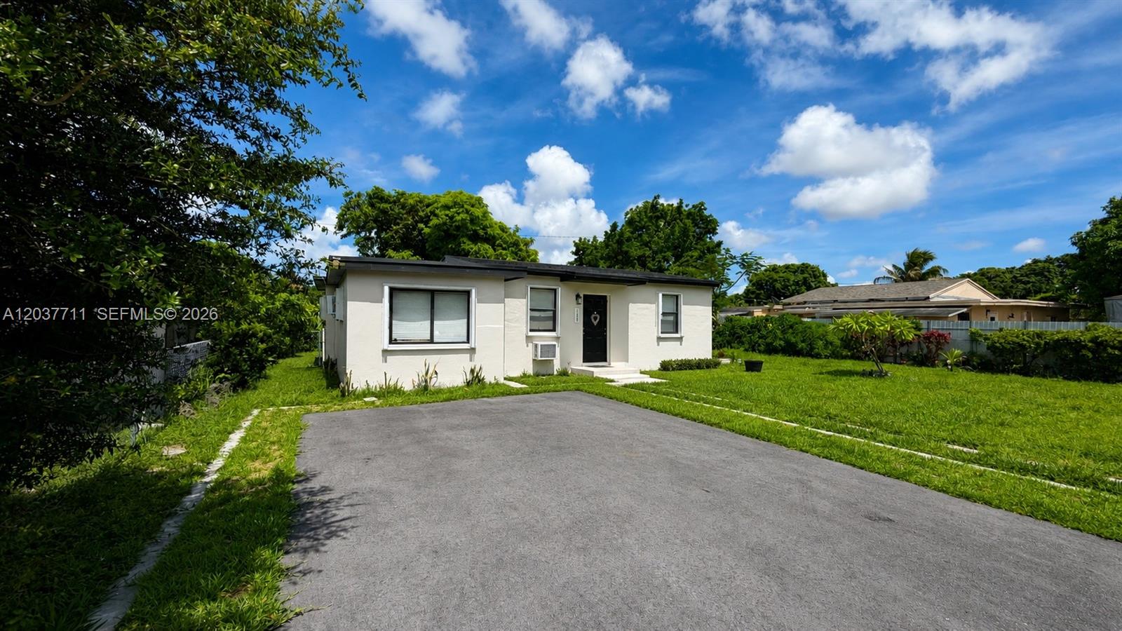 A single-story white house with a flat roof sits behind a paved driveway — 17981 NW 3rd Ave, Miami Gardens FL 33169, MIAMI GARDENS, FL