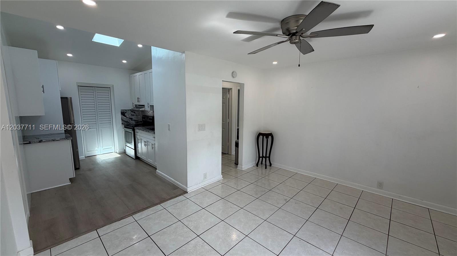 A kitchen with white cabinets and a dining area with tile flooring and ceiling fan — 17981 NW 3rd Ave, Miami Gardens FL 33169, MIAMI GARDENS, FL