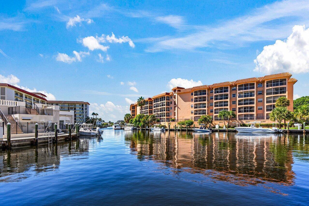 A canal view of multi-story apartment buildings with docked boats and reflections on the water — 2871 N Ocean Boulevard # C417, Boca Raton FL 33431, BOCA RATON, FL