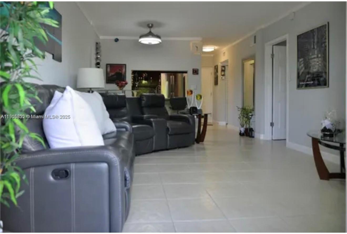 A living room features gray leather reclining sofas, light tile flooring, and a ceiling fan — 10900 SW 104th St # 314, Miami FL 33176, MIAMI, FL