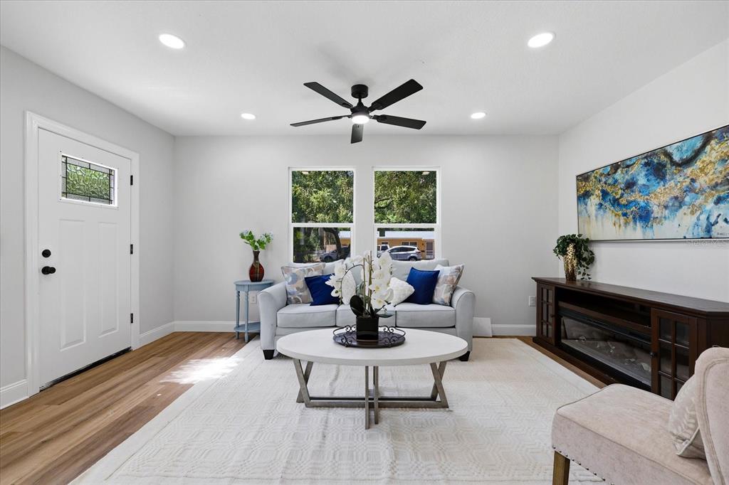 A living room features a white sofa, a round coffee table, and a dark media console — 7206 RHODE ISLAND DRIVE, TAMPA, FL
