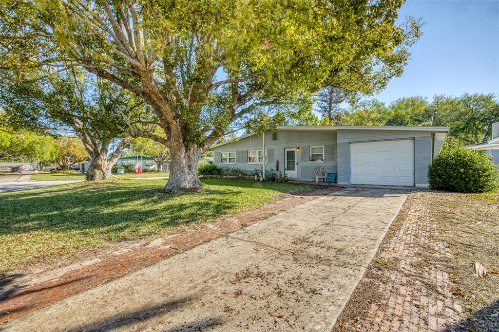 A single-story house with a concrete driveway, a garage, and large trees in the yard — 2821 OAK LEA DRIVE, SOUTH DAYTONA, FL