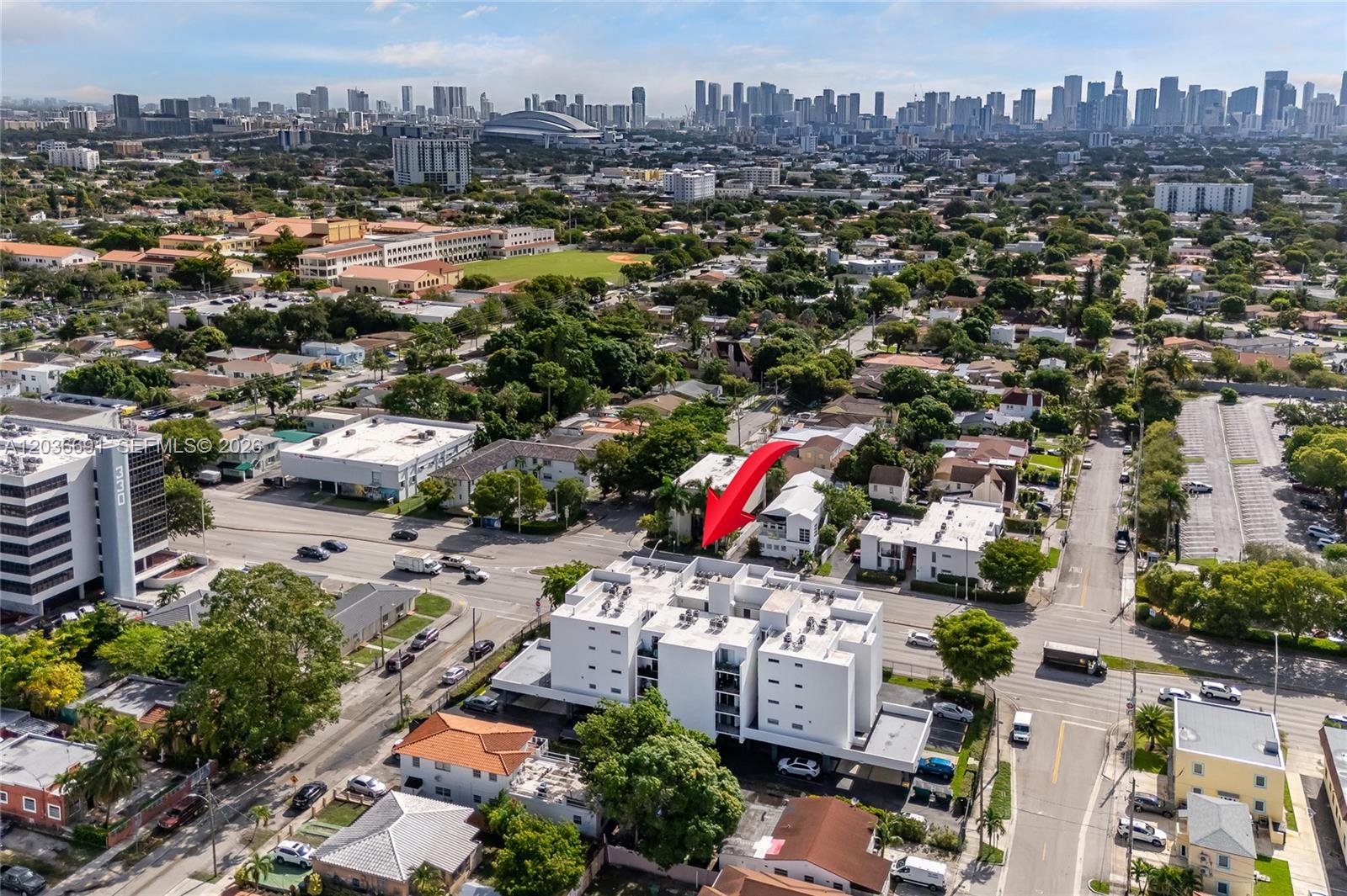 An aerial view shows a white multi-story apartment building surrounded by suburban streets and trees — 444 SW 27th Ave # 50, Miami FL 33135, MIAMI, FL