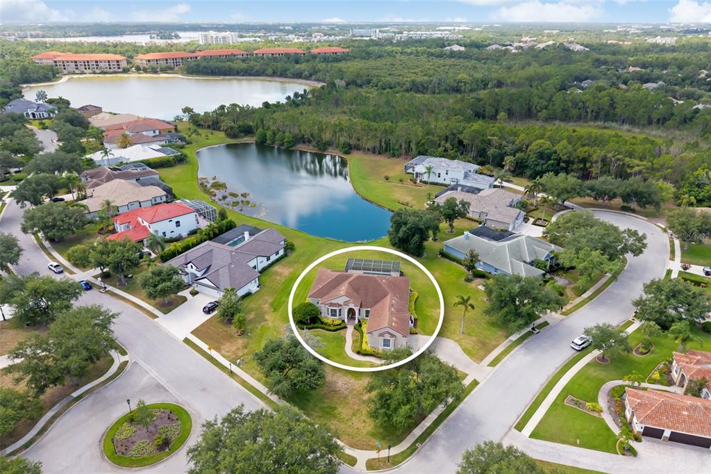 An aerial view shows a single-story house with a brown roof and pool enclosure — 7505 COVENTRY COURT, BRADENTON, FL