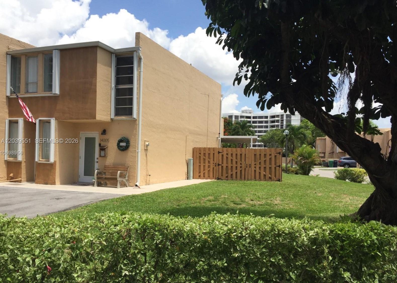 A tan two-story townhouse with a wooden fence and a front lawn — 14005 SW 67th Ter, Miami FL 33183, MIAMI, FL