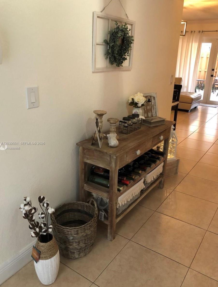 A wooden console table with wine storage sits in a hallway with tiled floors — 14005 SW 67th Ter, Miami FL 33183, MIAMI, FL