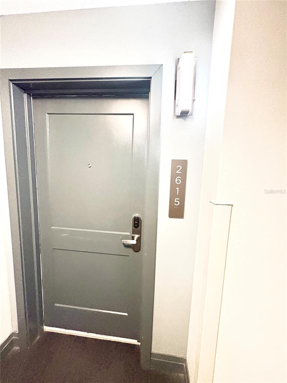 A gray apartment door with a digital lock and the number 2615 on the wall — 14501 GROVE RESORT AVENUE UNIT 2615, WINTER GARDEN, FL