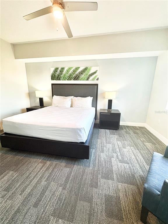A bedroom features a bed with a dark headboard, two nightstands, and patterned carpeting — 14501 GROVE RESORT AVENUE UNIT 2615, WINTER GARDEN, FL