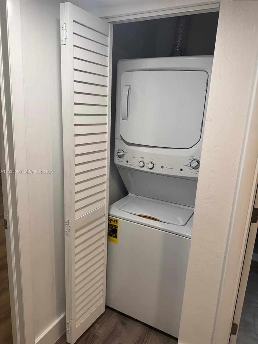A stacked washer and dryer unit is installed inside a small closet with louvered doors — 350 SW 15th Rd # 9, Miami FL 33129, MIAMI, FL