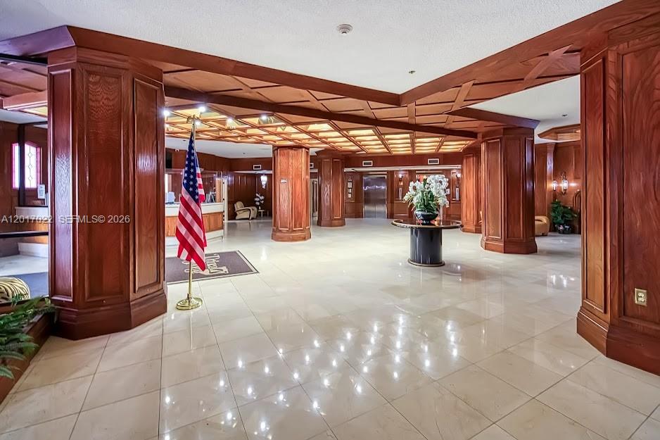 A spacious lobby features wood-paneled columns, a coffered ceiling, and a polished tile floor — 1865 S Ocean Dr # 15C, Hallandale Beach FL 33009, HALLANDALE BEACH, FL