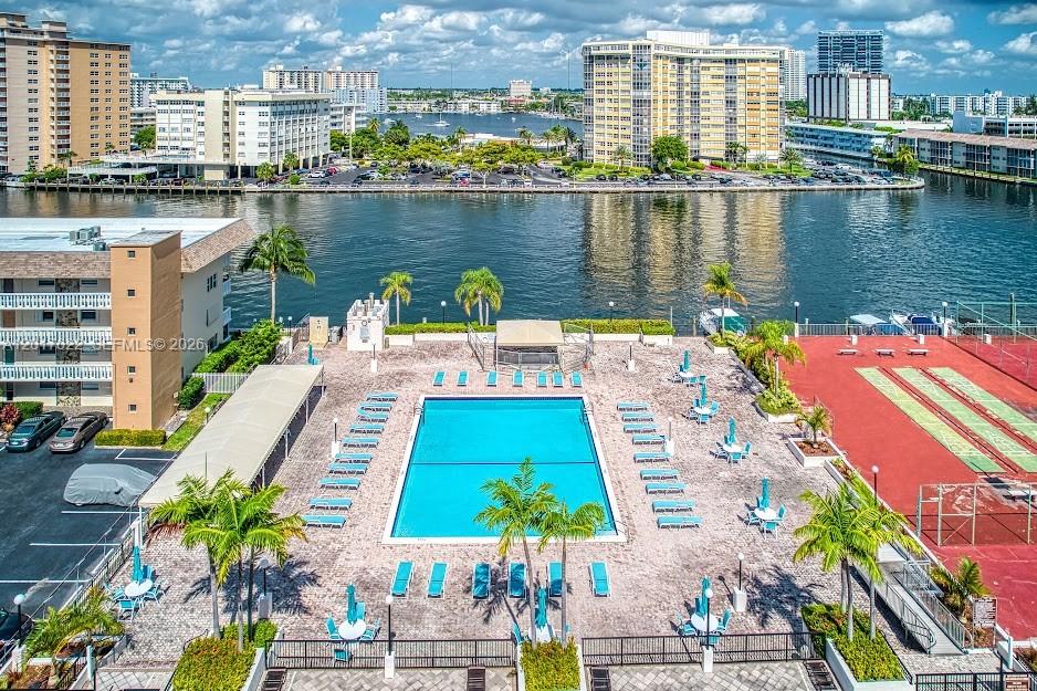 An aerial view shows a swimming pool, lounge chairs, and a shuffleboard court by water — 1865 S Ocean Dr # 15C, Hallandale Beach FL 33009, HALLANDALE BEACH, FL