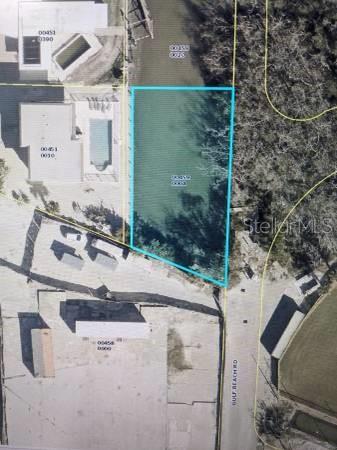 This aerial map shows a vacant rectangular lot outlined in blue next to a road — TROPICAL SHORE WAY, FORT MYERS BEACH, FL