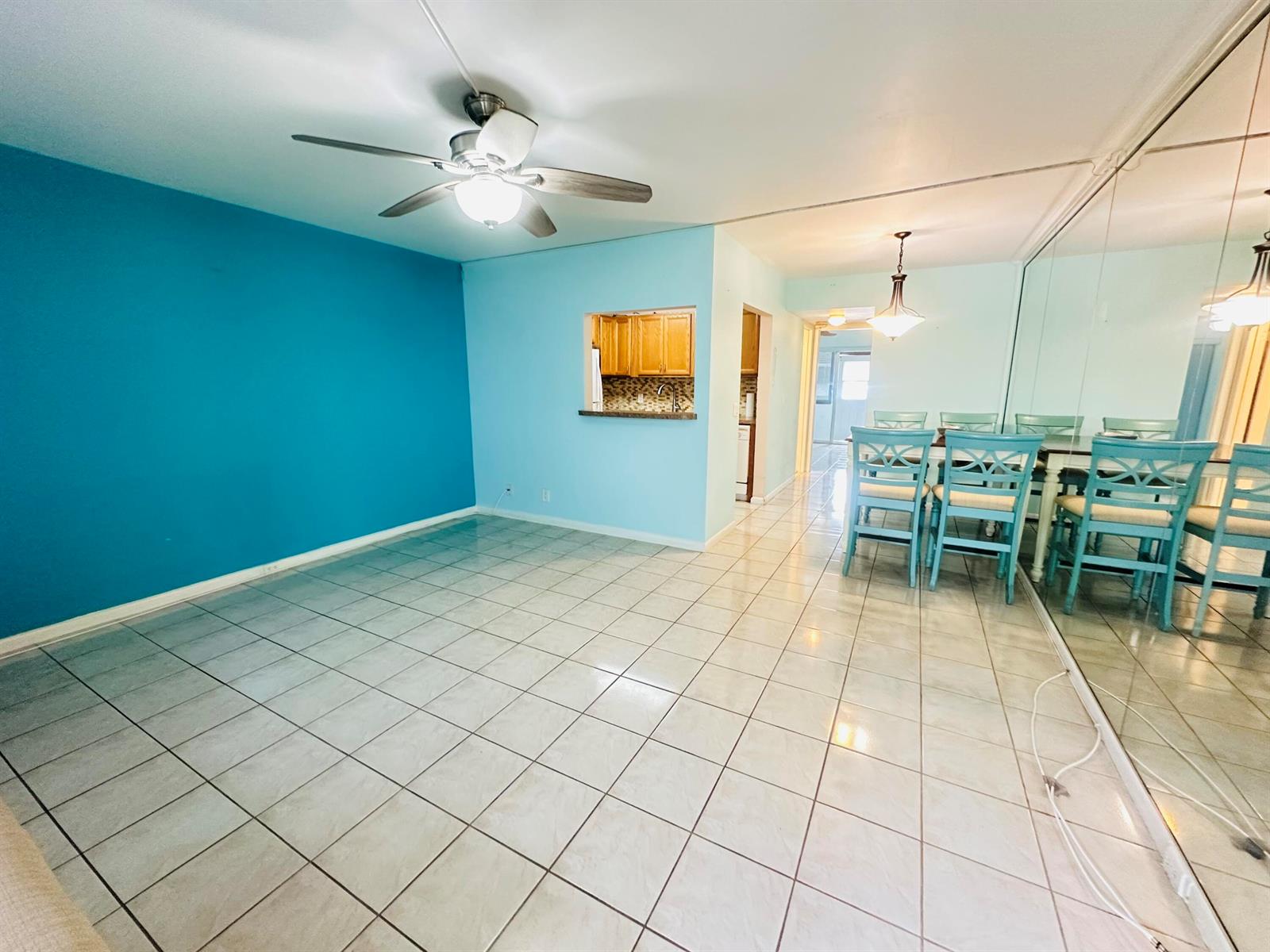 A living and dining area features blue walls, tiled floors, and a mirrored wall — 86 Markham E, Deerfield Beach FL 33442, DEERFIELD BEACH, FL