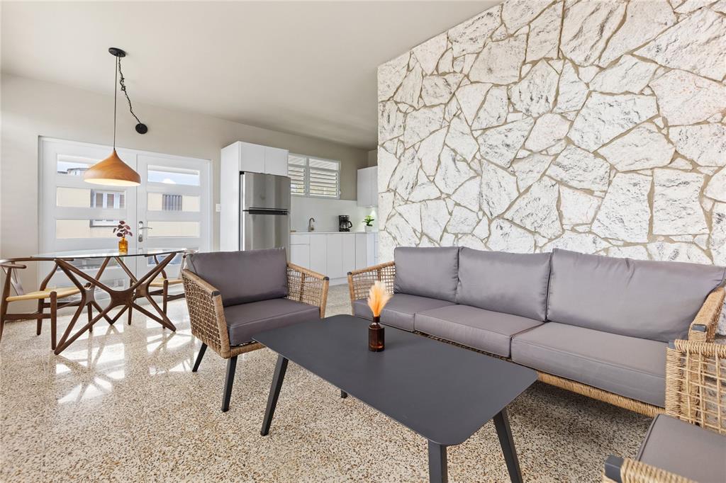 A living room and kitchen area features a stone accent wall and terrazzo flooring — 56 MARÍA MOCZO UNIT 2, SAN JUAN, PR