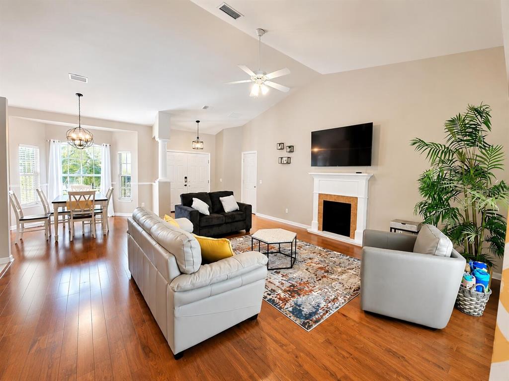 A living room with hardwood floors, a fireplace, and an adjacent dining area — 4394 GLORDANO AVENUE, NORTH PORT, FL