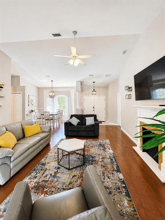A living room features hardwood floors, a large area rug, and a fireplace with TV — 4394 GLORDANO AVENUE, NORTH PORT, FL