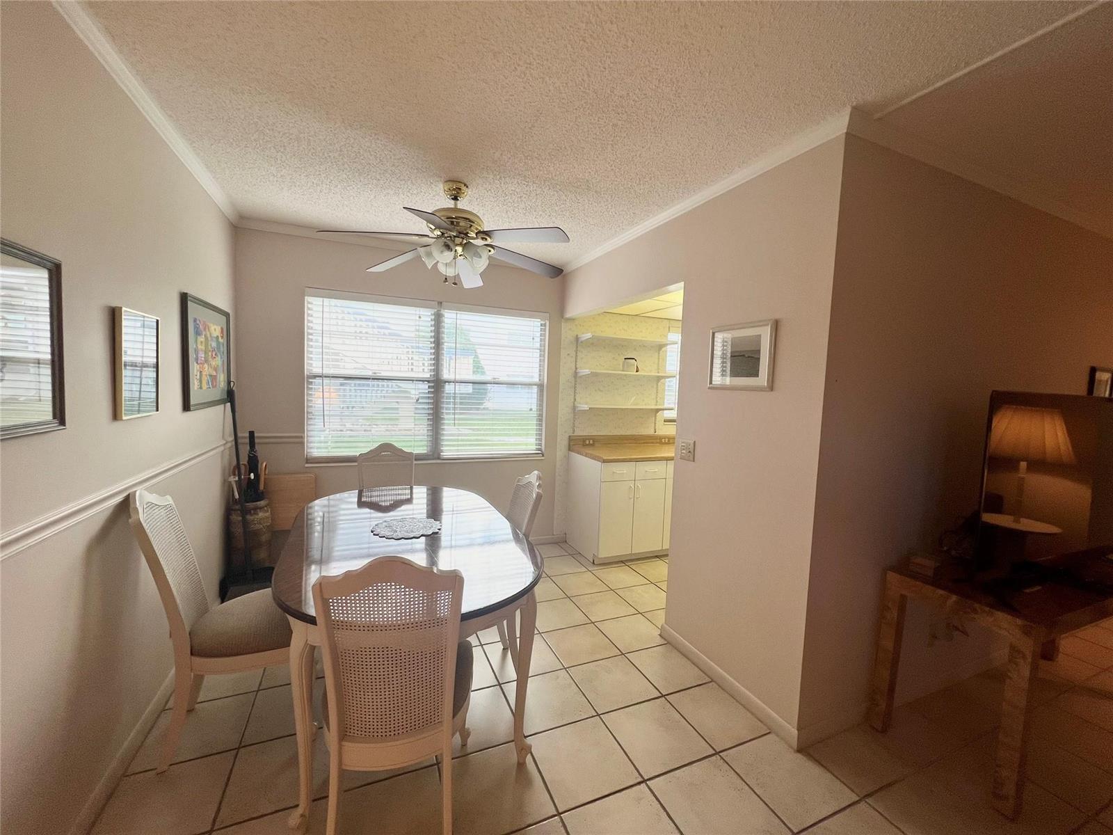 A dining room features a glass-top table, four chairs, tile flooring, and a ceiling fan — 244 Farnham K # 244, Deerfield Beach FL 33442, DEERFIELD BEACH, FL