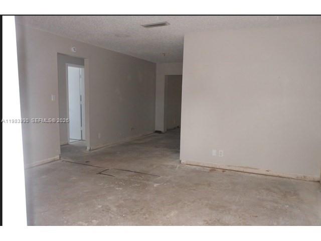 An empty room with light-colored walls and bare concrete flooring — 7540 Margate Blvd, Margate FL 33063, MARGATE, FL