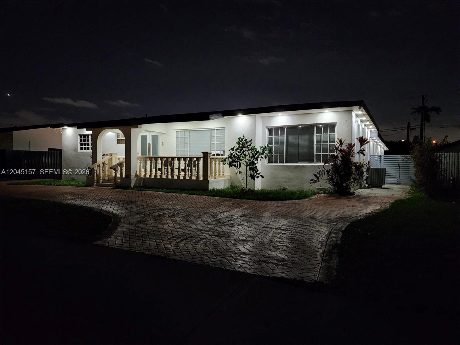 A single-story house with a white exterior, a front porch, and blooming bougainvillea bushes — 8240 SW 38th St, Miami FL 33155, MIAMI, FL