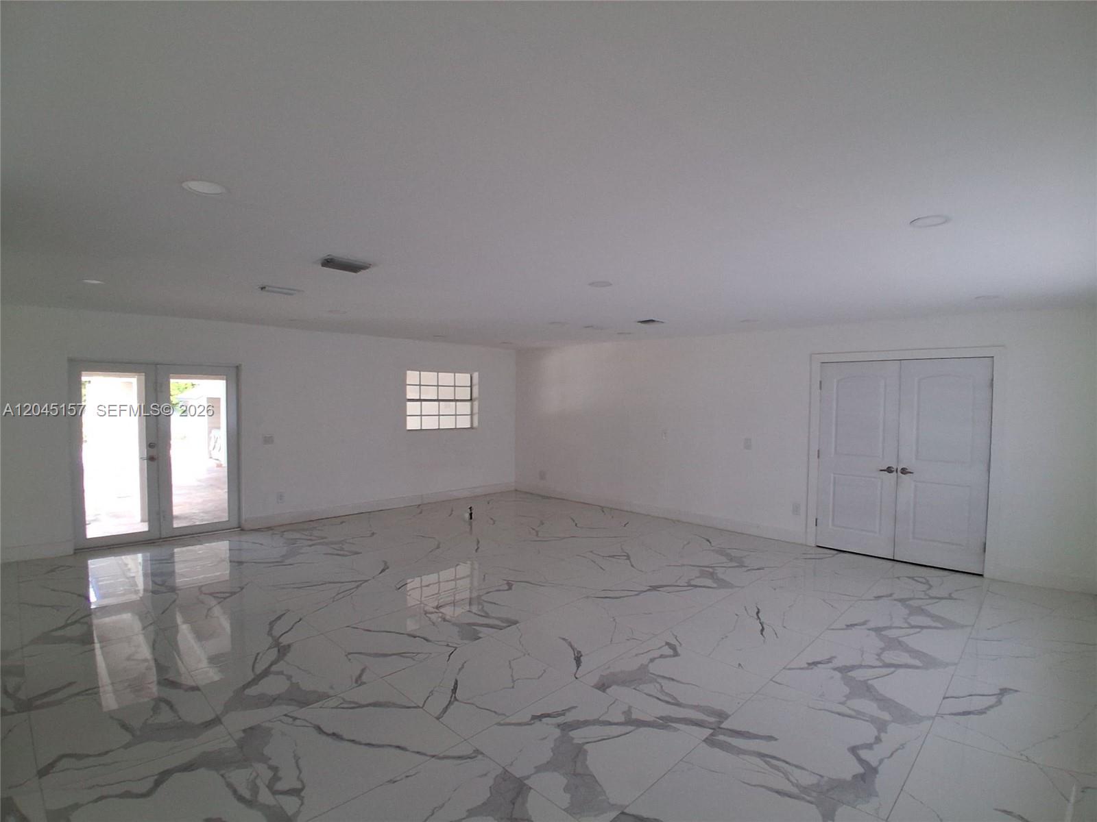 A white house with a covered patio overlooks a kidney-shaped swimming pool and concrete deck — 8240 SW 38th St, Miami FL 33155, MIAMI, FL