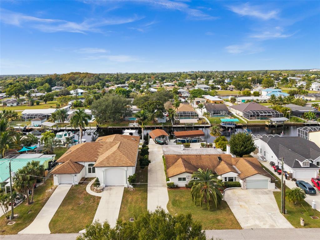 An aerial view shows two adjacent suburban houses with driveways and private boat docks — 2129 W TOBAGO CIRCLE, FORT MYERS, FL