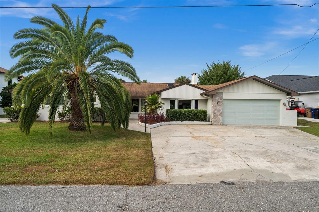 A single-story house with a palm tree, concrete driveway, and attached two-car garage — 2129 W TOBAGO CIRCLE, FORT MYERS, FL